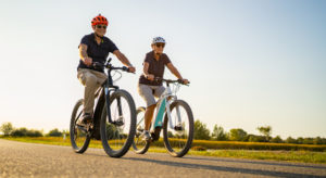 Couple biking safely on a bike trail