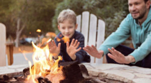 Father and son around fire practicing fire pit safety