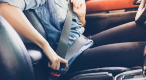 person buckling their seatbelt