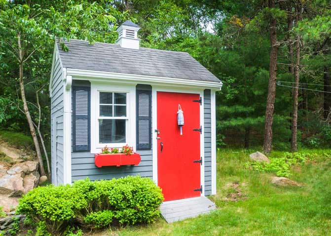 Grey sided shed with a red door
