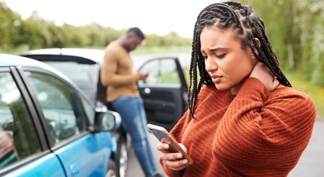 Woman and man calling on phones at car accident