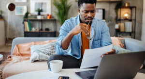 Man sitting on sofa learning about why car insurance premiums increase