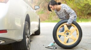 Young woman preparing to change a flat tire