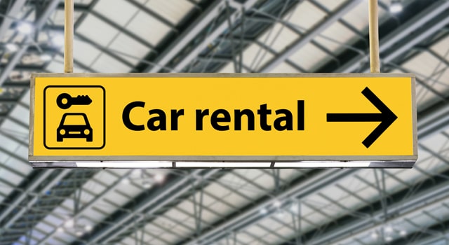 Sign pointing to car rental service that insurance can pay for.