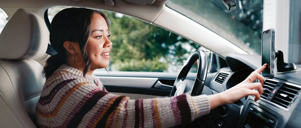 woman in car checking gps on mobile
