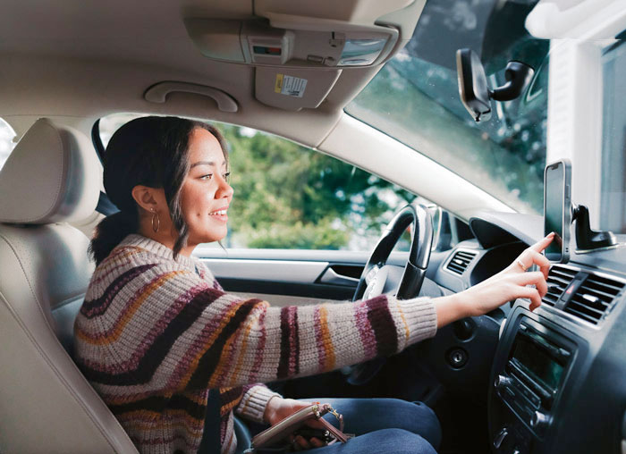 woman in car getting ready to drive setting up her yubi app on phone