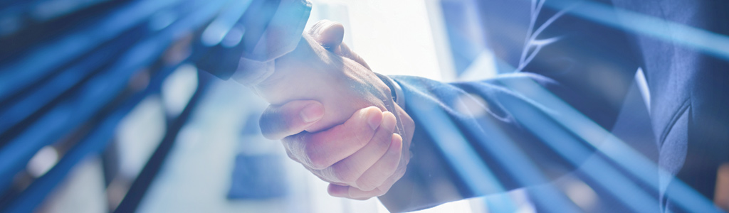 two men shaking ands with a blue blurred background