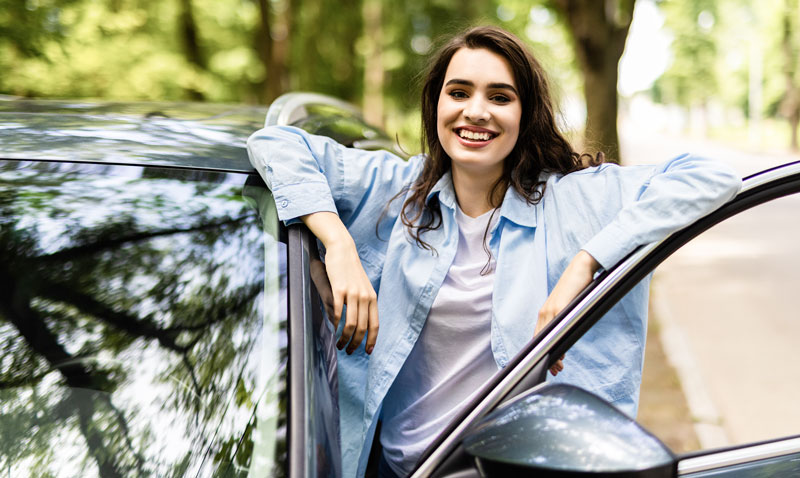 Photo of a woman standing in front of a car