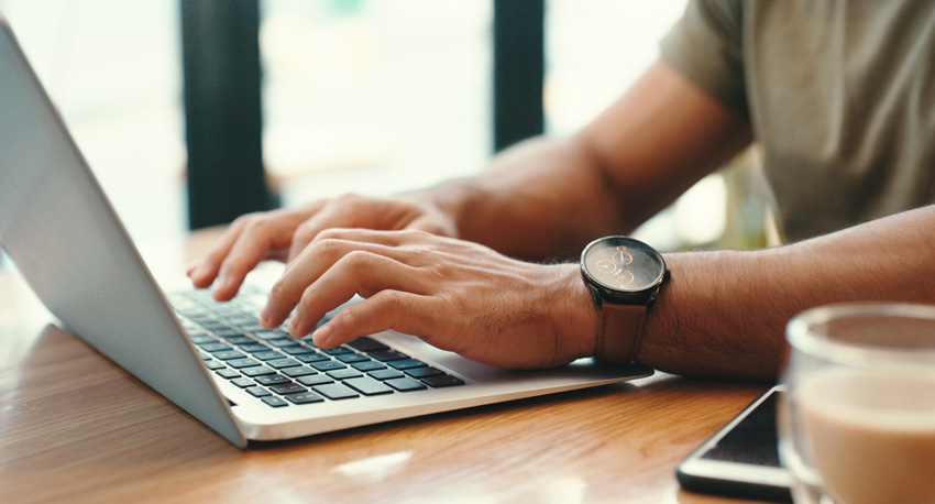 photo of hands typing on a laptop keyboard