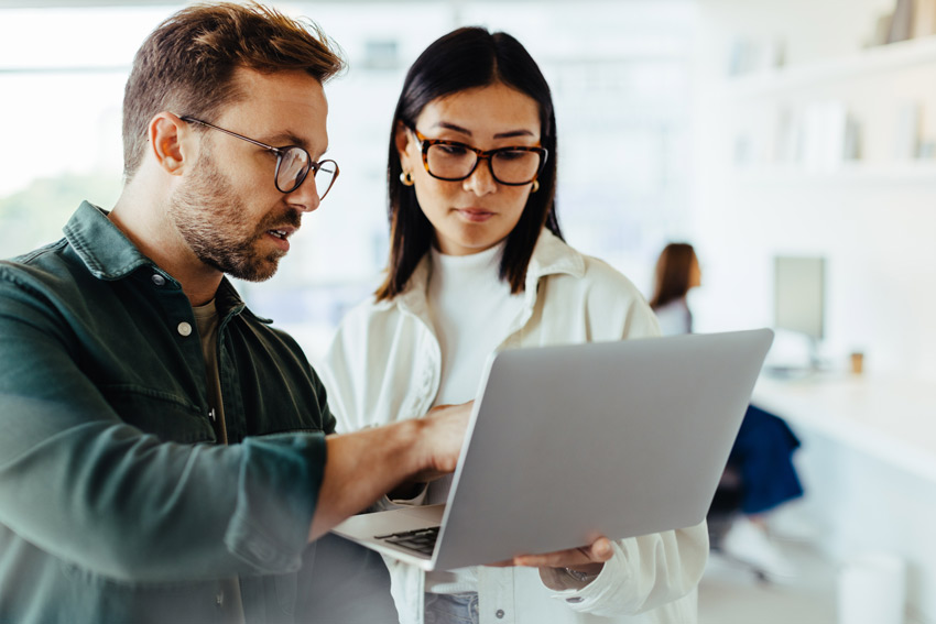 Photo of a man and a woman looking at a laptop