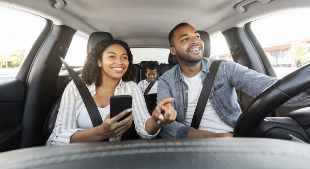 Young couple with their son driving