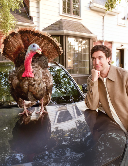Man looking at turkey on hood of his car