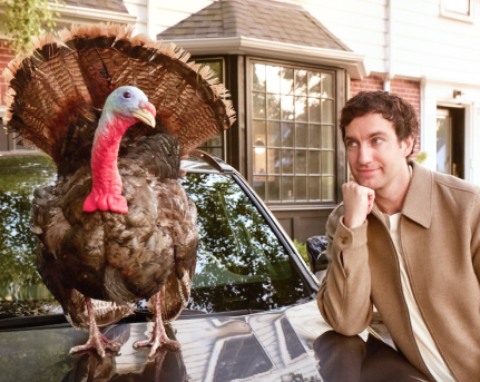 Man looking at turkey on the hood of his car