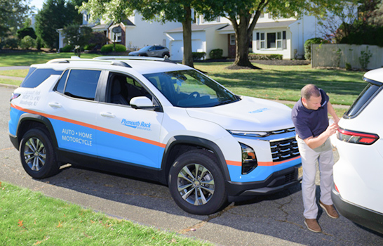 Crashbuster SUV with Insurance adjuster looking at damage to another SUV