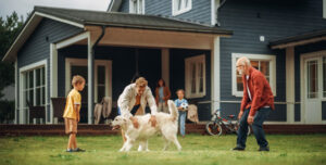 Family playing with their dog in front of their back porch