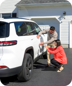 Husband and wife reviewing damage to side of white SUV